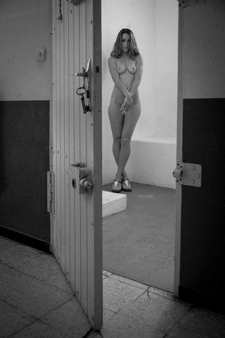 Photo de femme nue debout dans une cellule entre-ouverte